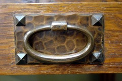 Close-up hand-hammered copper pull, early style with oval loop and pyramid screws.